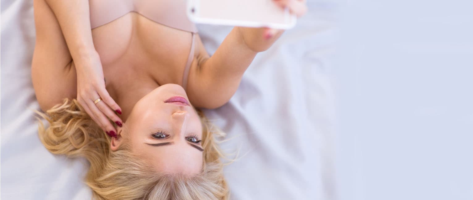 woman taking a selfie in bed